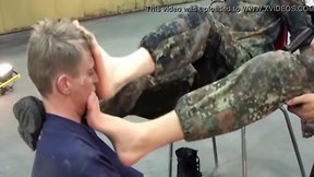 A lucky guy is allowed to lick the boots of two german soldiers